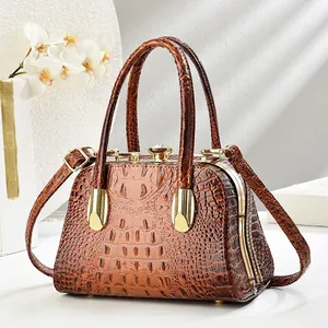 Detailed view of brown crocodile texture and gold hardware on evening handbag