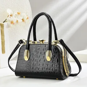Close-up of black crocodile pattern leather evening bag with golden jeweled clasp