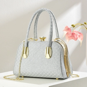 Sparkling silver glitter evening clutch bag with gold metal handle and crystal clasp