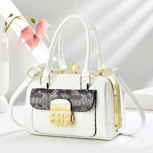 Macro shot of white crocodile embossed texture and vintage pearl clasp on luxury handbag