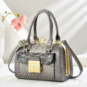 Detail of grey crocodile texture handbag with gold metal clasp and pearl buckle
