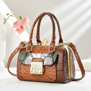 Detail of brown crocodile pattern handbag featuring a pearl buckle and stylish snake print flap