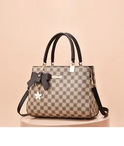 Detail of checkered vintage handbag featuring bow charm and gold-toned metal logo