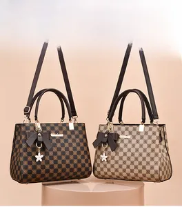 Detail view of checkerboard tote bags with leather bows and floral charms in two colors