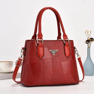 Detail of red leather bucket bag with MS.ISHIANG logo, stitching and gold hardware