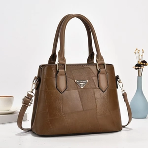 Detail of dark brown leather bucket bag with metallic logo and adjustable strap