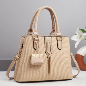 Beige woven leather tote bag with gold hardware and tassel detail for summer fashion