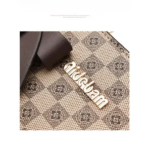 Detailed macro view of the golden metal logo and checkered pattern on the leather handbag