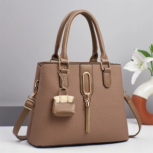 Close-up of brown woven tote with gold hardware and stylish fringe tassel detail