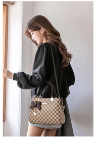 Detail showing checkered patterns and a bow charm on a retro-style handbag