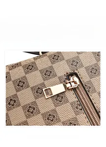 Close-up of checkerboard floral canvas texture and polished gold zipper on the handbag