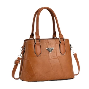 Brown geometric patchwork leather bucket bag with top handle and adjustable shoulder strap