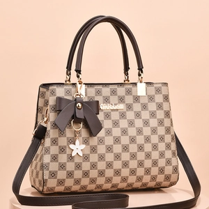 Retro checkered tote bag with brown bow charm and gold hardware on beige pedestal