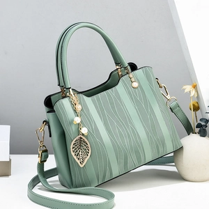 Elegant mint green handbag with leaf vein texture and pearl charm on a minimalist background