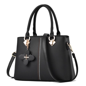 Classic black leather handbag with gold hardware and floral pendant for women