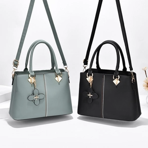 Elegant women's handbag in grey-green and black leather with clover charms