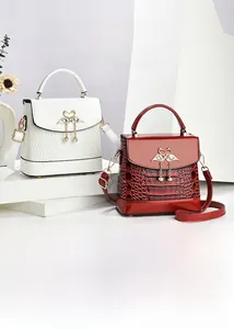 Détail de la texture crocodile et fermoir cygne doré avec perle sur sac à main