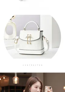Détail du sac seau blanc motif crocodile avec fermoir cygne doré et perles blanches