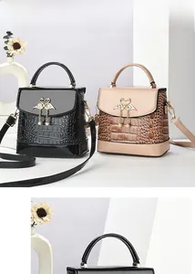 Détail du mini sac à main avec motif crocodile, ornement cygne et pendentif perle