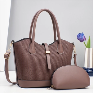 Detail of coffee brown pleated tote bag and pouch set with golden hardware and strap