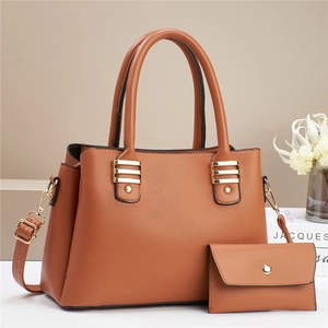Brown lychee leather tote bag and envelope wallet set with gold hardware on beige background