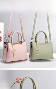 Detail of pink and green pebble leather tote with pearl charm and fine stitching