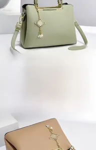 Detail of lychee pattern leather tote bag with gold metal handle and luxury pendant