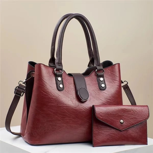 Chic burgundy glossy leather tote bag with matching pouch and adjustable shoulder strap