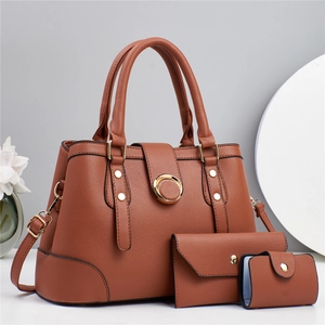Close-up of brown litchi pattern leather handbags with elegant gold ring hardware details