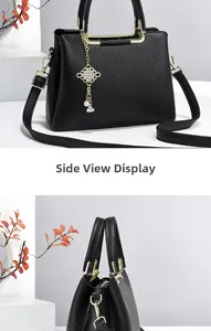 Detail of black litchi pattern tote bag with gold hardware and chinese knot pendant