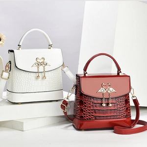 Elegant crocodile pattern tote bags in white and burgundy with swan metal clasps
