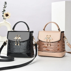 Elegant crocodile-patterned bucket tote bags in black and khaki with swan buckles