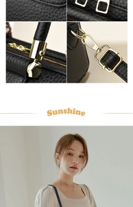 Macro details of black lychee grain leather, gold hardware, and tote bag strap buckle