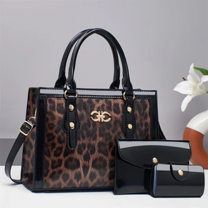 Detail of leopard print tote bag with shiny black patent leather and gold metal logo