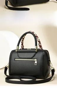 Detail of black lychee texture tote with silk scarf handle and golden zipper hardware