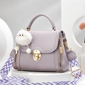 Sac seau lavande grainé avec pendentif pompon et bandoulière tissée à motifs géométriques