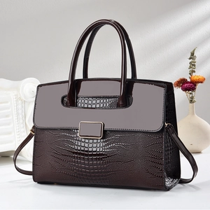 Détail d'un sac à main marron foncé à motif crocodile avec rabat brillant et boucle métal