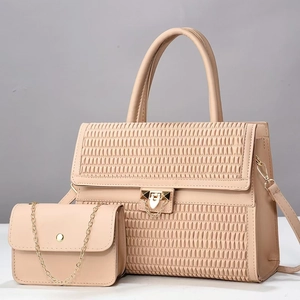 Detail view of woven texture and gold clasp on apricot faux leather tote and chain bag