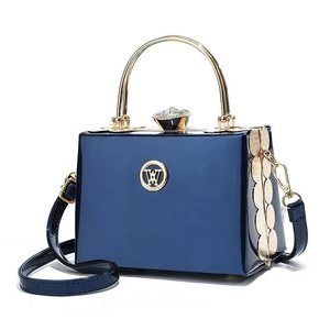 Navy blue patent leather box clutch with gold handle and sparkling gemstone clasp