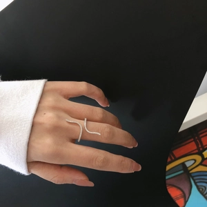 Bague vaguelette argentée en forme de S ornée de zircons scintillants portée