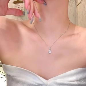 Elegant silver teardrop zircon necklace on a model with a fine metal link chain