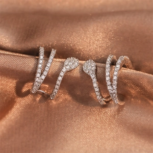 Sparkling snake-shaped ear cuffs with AAA zircons on a luxury silk fabric background