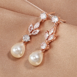 Macro detail of rose gold pearl earrings with champagne drop pearls and zircon inlay