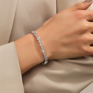 Elegant silver-toned bangle with irregular cubic zirconia stones on model's wrist