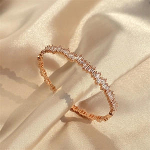 Detailed macro view of rose gold bangle featuring pavé-set rectangular cubic zirconia stones
