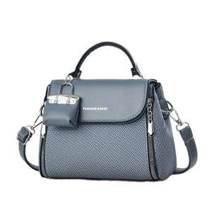 Elegant grey-blue woven leather handbag with top handle and adjustable shoulder strap