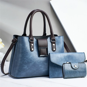Detailed view of the blue three-piece bag set with textured leather and metal buckles