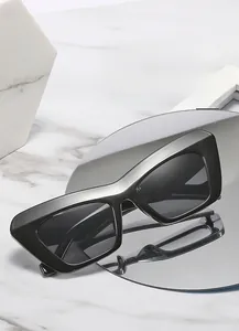 Close-up of black rectangular cat-eye sunglasses with CE marking on wide temple arms