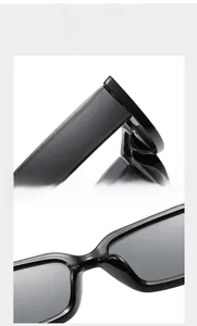 Close-up of black rectangular rimless sunglasses frame with metallic hinge details