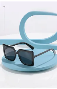 Gros plan de lunettes de soleil carrées oversize sur présentoir bleu géométrique